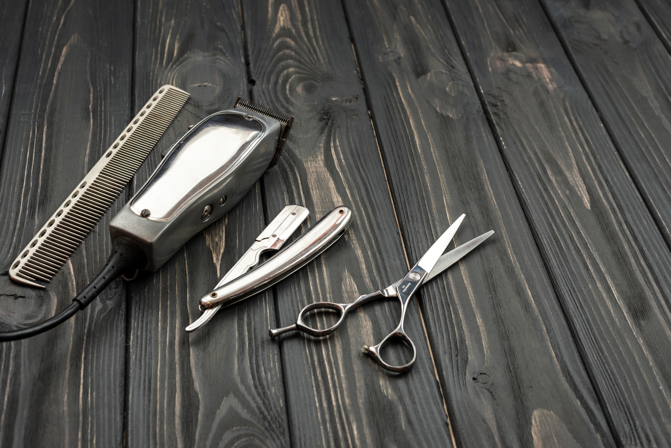 Men's Haircut Tools on a Wooden, Dark Background.