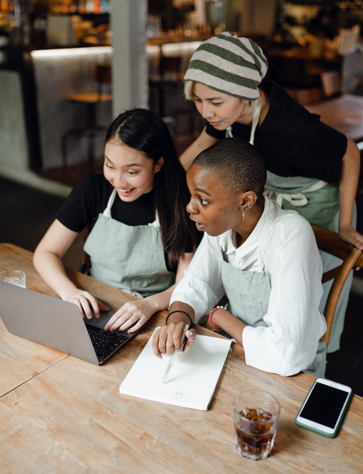 Amazed diverse colleagues working on laptop in modern workspace